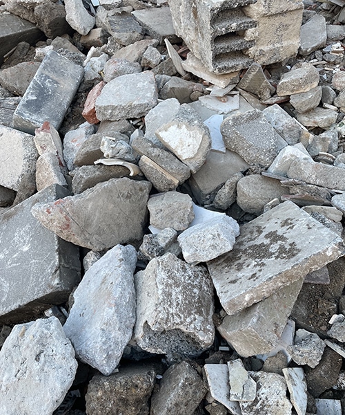 Schwerer Bauschutt mit Beton und Ziegeln in einem Container zur fachgerechten Entsorgung
